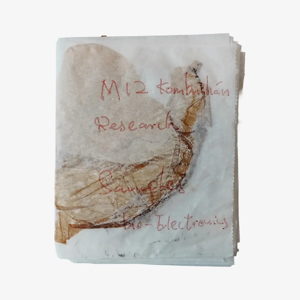 The cover of a handmade booklet with a cellulose sheet and handwritten red lettering.