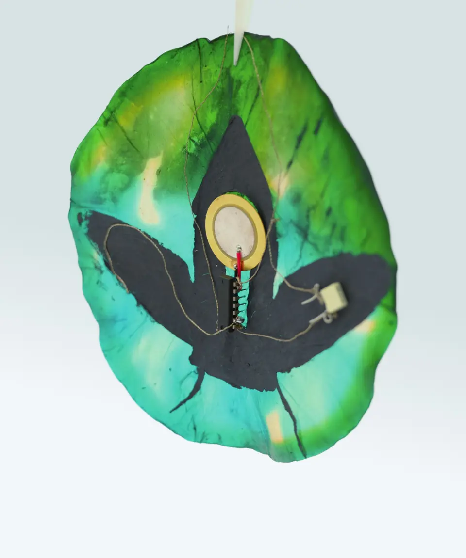 The back of the hanging cicada piece with a piezo disc and chip stitched on.