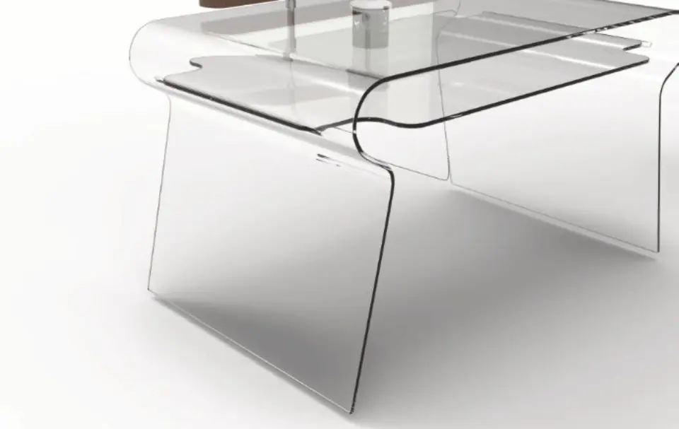 A curved, transparent desk seen from a low angle, with a slim shelf above the worktop.