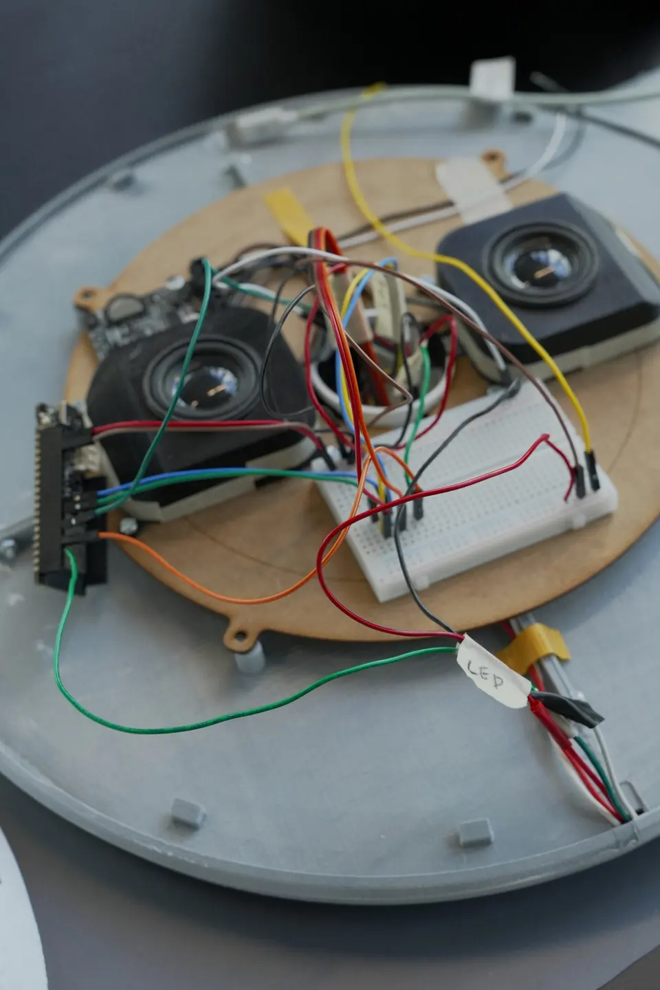 The opened device: an ESP32 board, a breadboard, wires and a speaker on a round base.