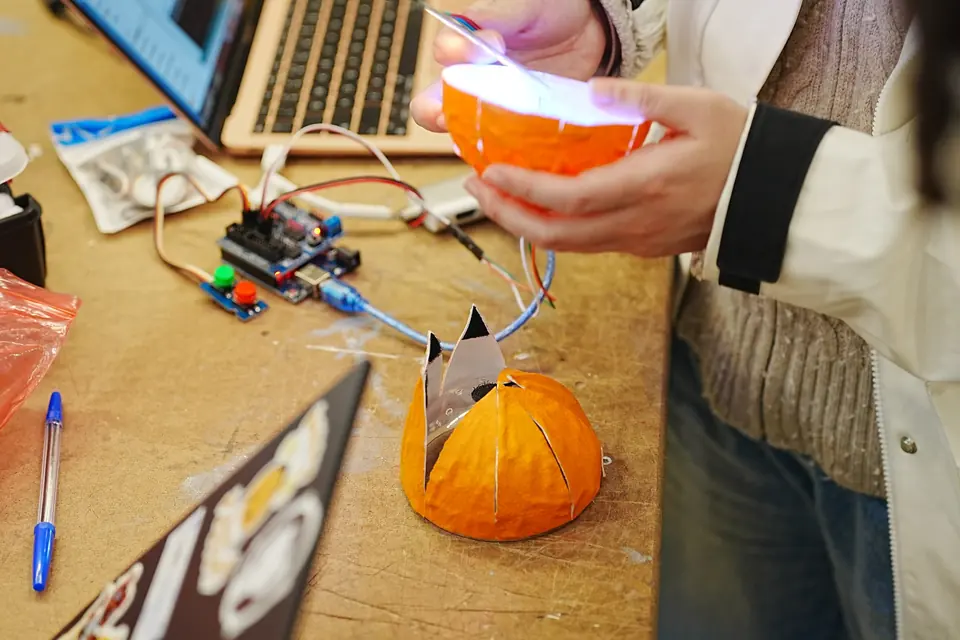 The orange prototype on a cluttered workbench, wired to a microcontroller.