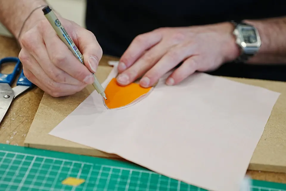 Four strips of orange material on a green cutting mat.