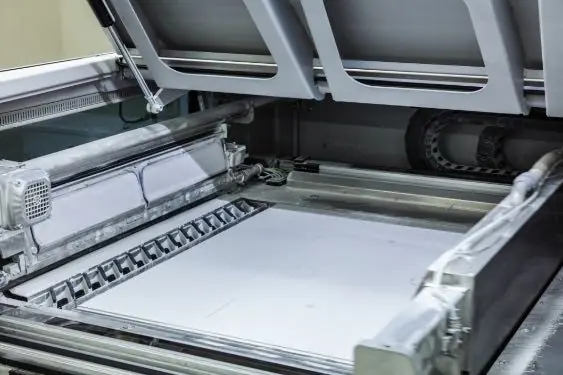 The build bed of a binder-jet 3D printer, spread with white ceramic powder.