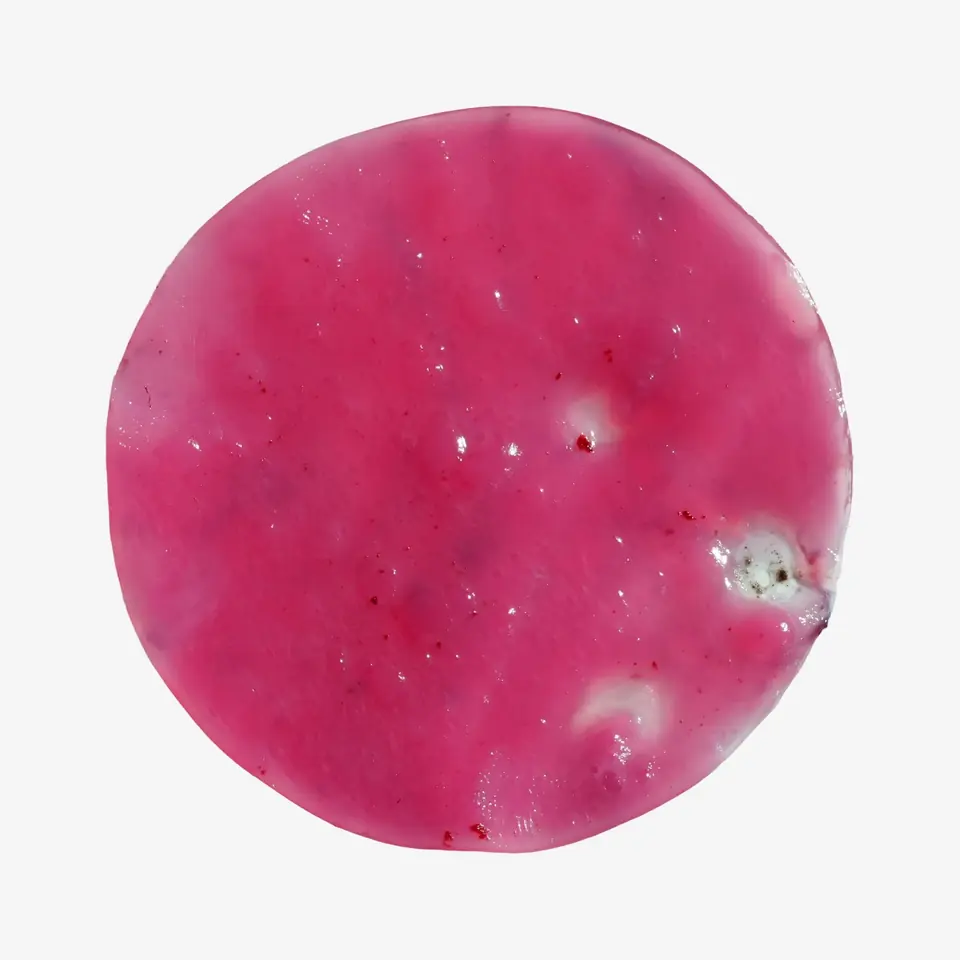 A wet, magenta disc of film with small pale spots.