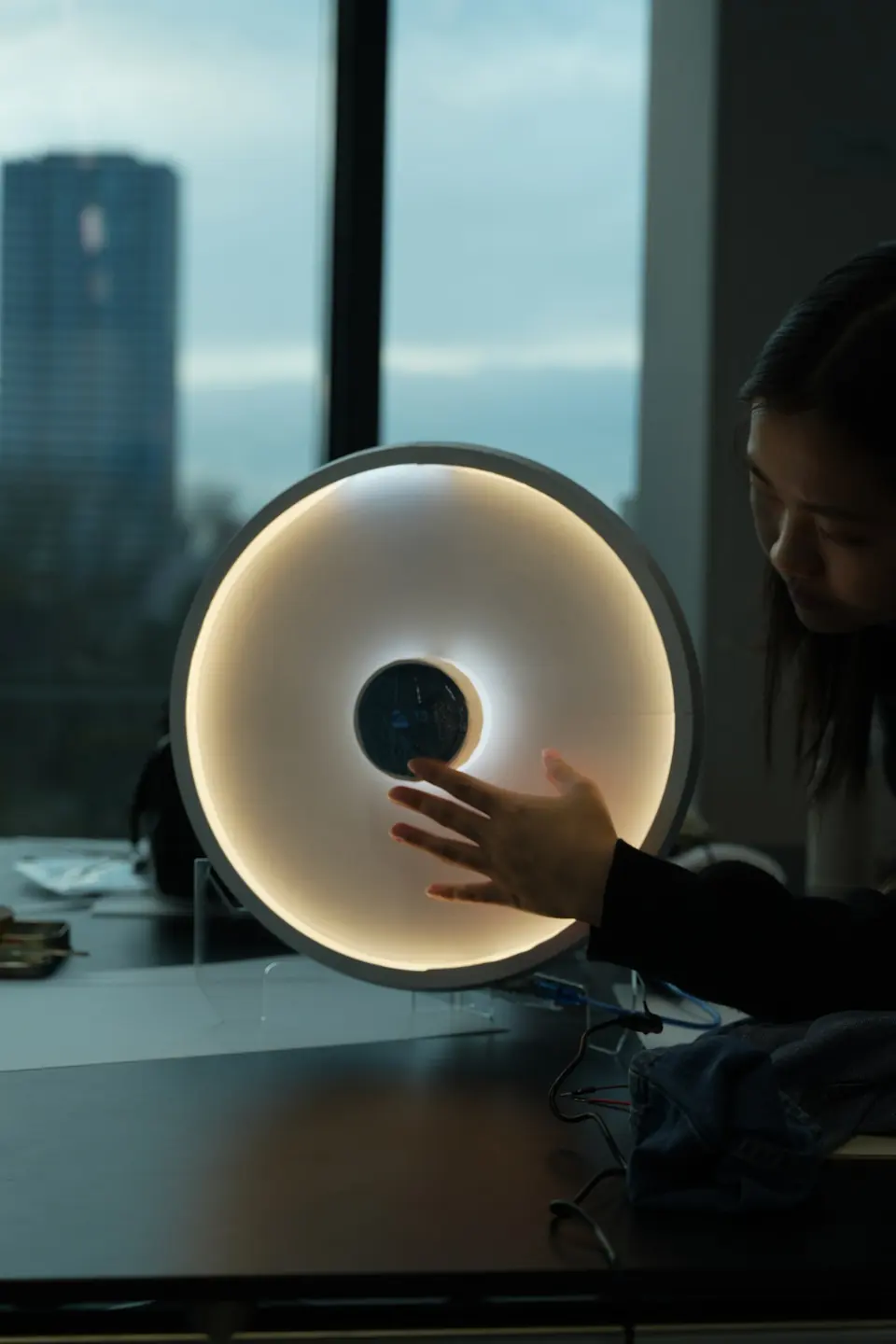 A hand reaches for the edge of the Carecast disc on a desk.